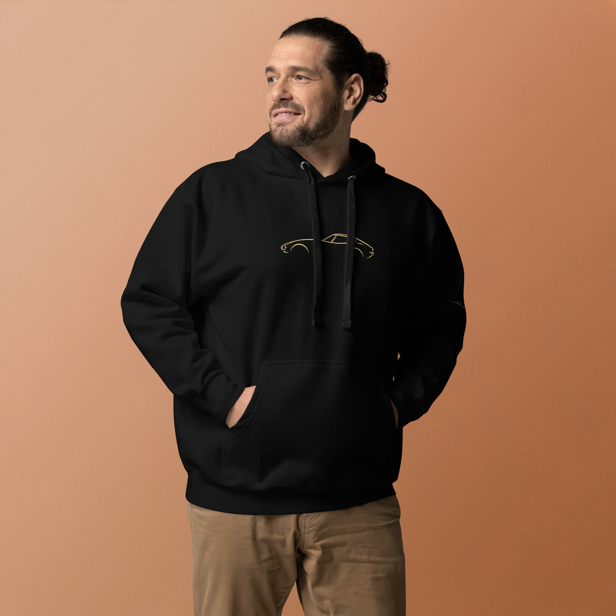 Toyota 2000GT Premium Hoodie in Black — model wearing the hoodie with gold chest artwork